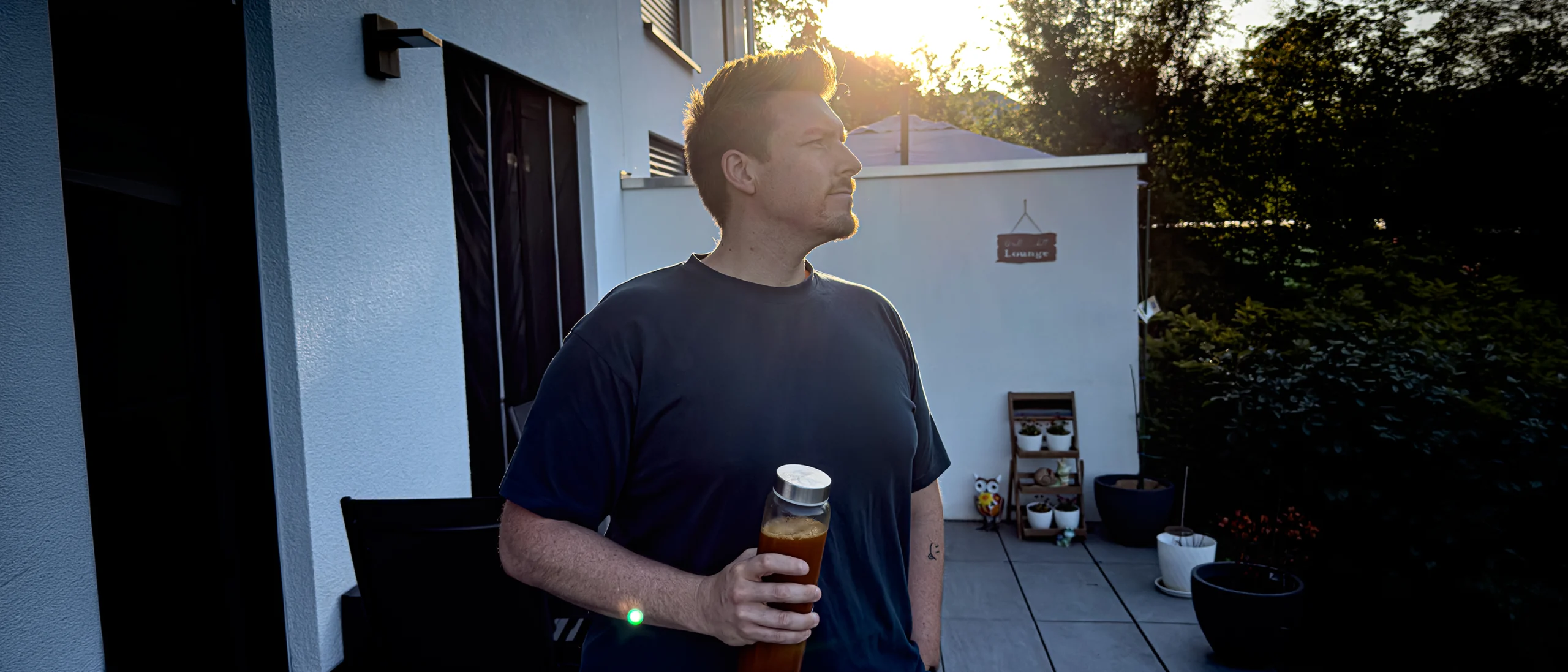 Thomas Müller abends auf der Terrasse, ein FitLine-Getränk in der Hand